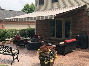 A Sunesta awning provides shade for a residential porch in the Northeast