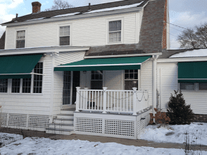 An awning is extended over a snowy porch in the Midwest